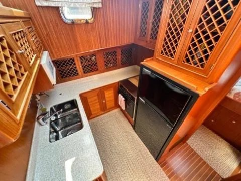 Brass Ring Yacht Photos Pics 2009 Marine Trader 36 Euro Sedan kitchen with wood cabinetry, dual sink, and compact refrigerator.