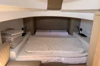 2023 SACS Strider 15 FB cabin interior with bed and folded linens.