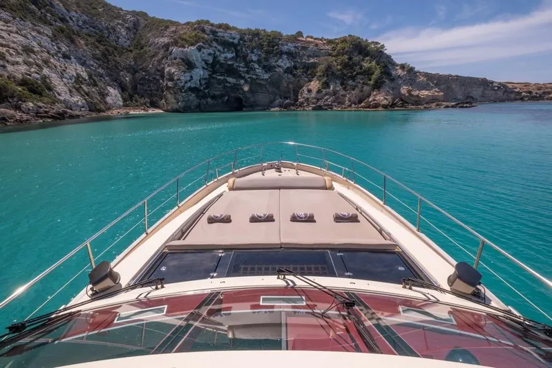 Vintage Yacht Photos Pics Luxury yacht cruising in turquoise waters near rocky coastline, Guy Couach 2100, 2006 model.