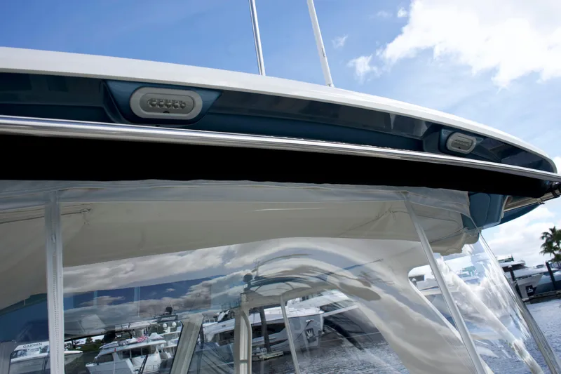 Yacht Kings Yacht Photos Pics 2020 Boston Whaler 350 Realm boat with clear canopy and sleek design against a marina backdrop.