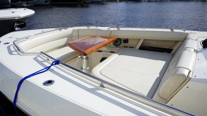 Yacht Kings Yacht Photos Pics 2020 Boston Whaler 350 Realm boat interior with seating and table, docked by the water.