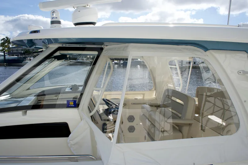 Yacht Kings Yacht Photos Pics 2020 Boston Whaler 350 Realm boat interior with helm and seating, docked by the water.
