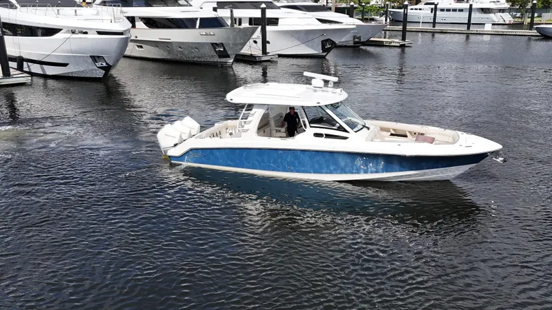 Yacht Kings Yacht Photos Pics 2020 Boston Whaler 350 Realm boat cruising in marina with yachts in background.