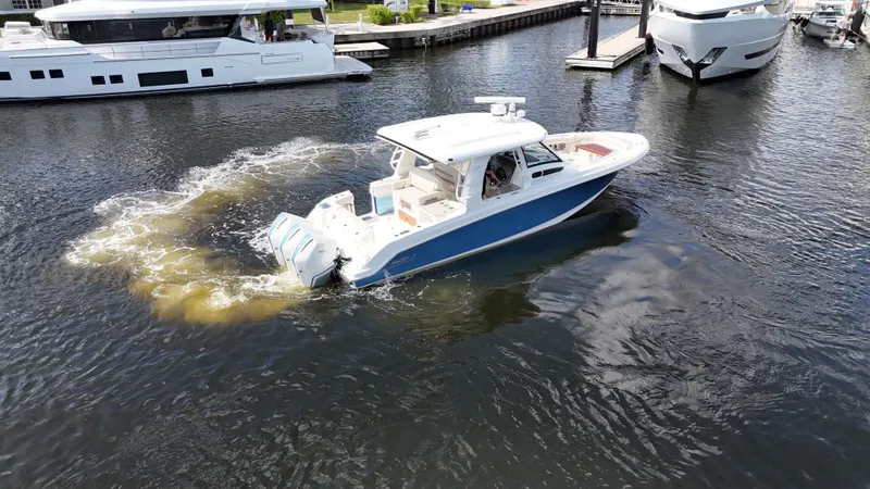 Yacht Kings Yacht Photos Pics 2020 Boston Whaler 350 Realm cruising in marina, surrounded by yachts.