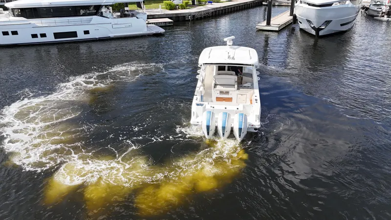 Yacht Kings Yacht Photos Pics 2020 Boston Whaler 350 Realm boat maneuvering in marina with visible wake.