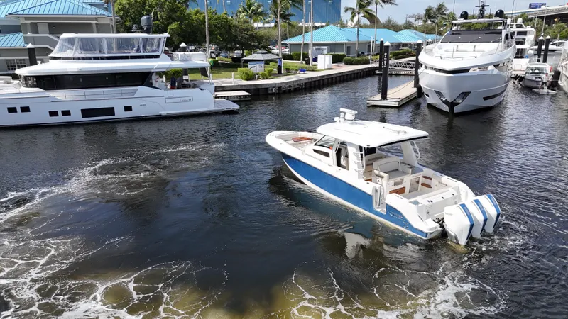 Yacht Kings Yacht Photos Pics 2020 Boston Whaler 350 Realm cruising in marina with luxury yachts.