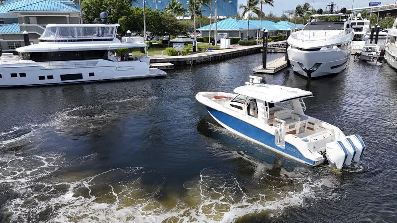 Yacht Kings Yacht Photos Pics 2020 Boston Whaler 350 Realm cruising in a marina with luxury yachts.