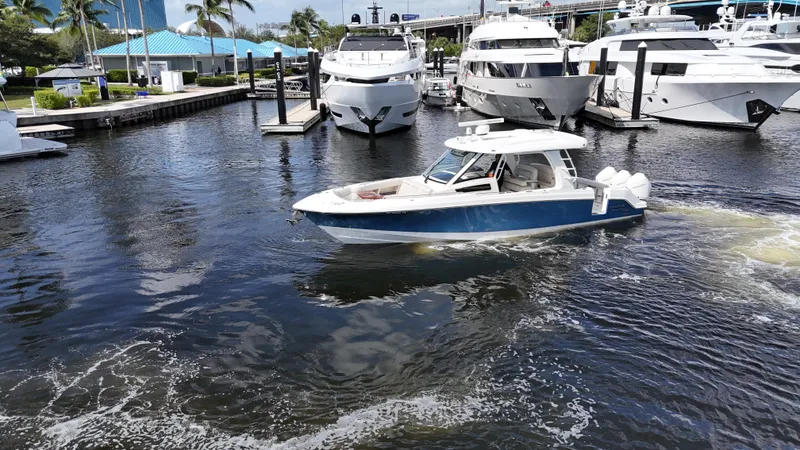 Yacht Kings Yacht Photos Pics 2020 Boston Whaler 350 Realm cruising in a marina with yachts and palm trees.