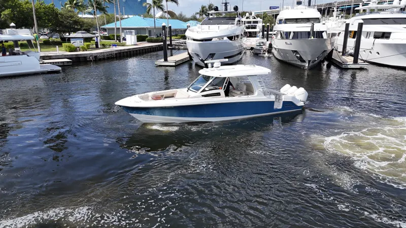 Yacht Kings Yacht Photos Pics 2020 Boston Whaler 350 Realm boat cruising in a marina with yachts docked nearby.