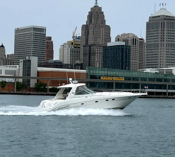  Yacht Photos Pics 2003 Sea Ray 460 Sundancer cruising on water with city skyline backdrop.