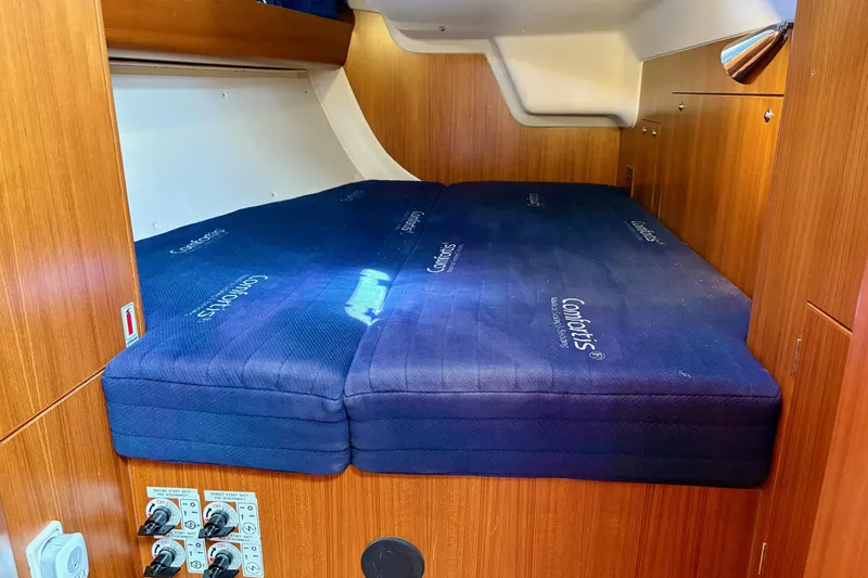  Yacht Photos Pics Cabin interior of 2006 X-Yachts X-50 with blue mattress and wooden finish.