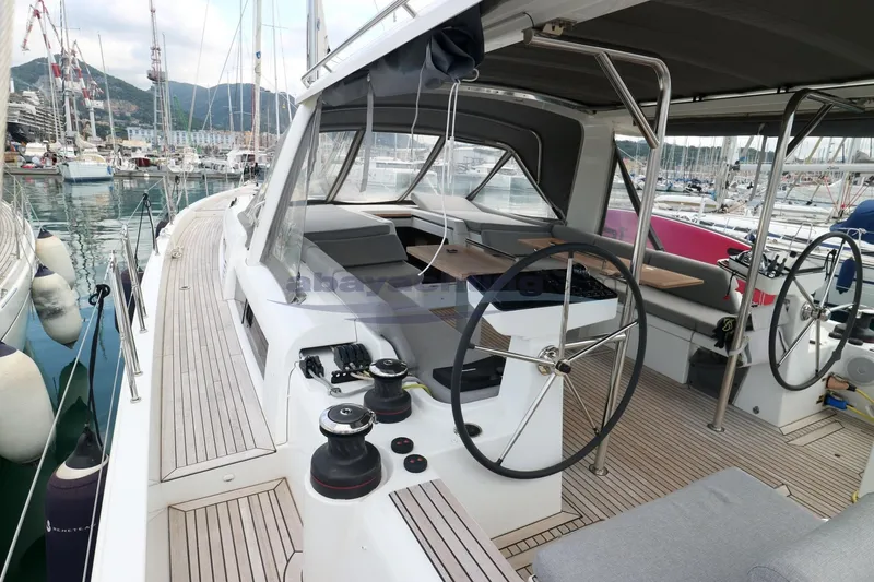  Yacht Photos Pics 2023 Beneteau Oceanis 54 yacht with dual steering wheels in a marina setting.