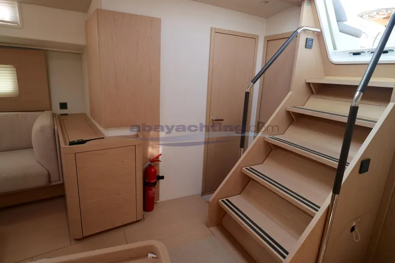  Yacht Photos Pics Modern interior of 2023 Beneteau Oceanis 54 yacht with wooden stairs and cabinetry.