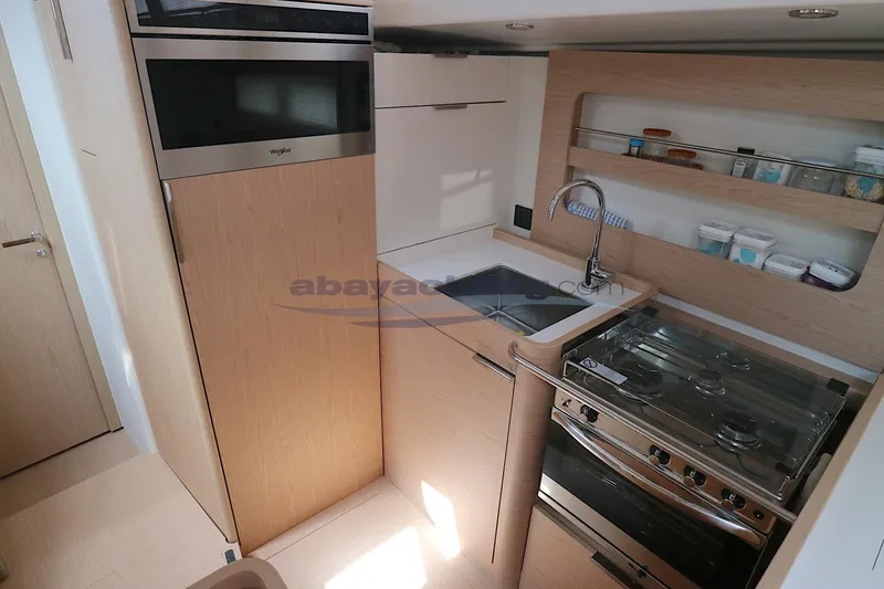  Yacht Photos Pics Modern kitchen in 2023 Beneteau Oceanis 54 yacht with stove, sink, and storage.
