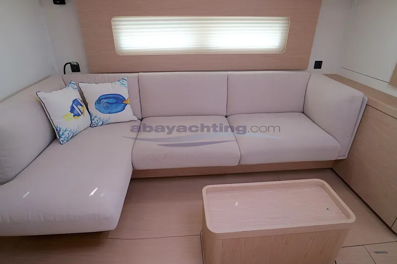  Yacht Photos Pics Modern interior of 2023 Beneteau Oceanis 54 yacht with cozy seating and decorative pillows.