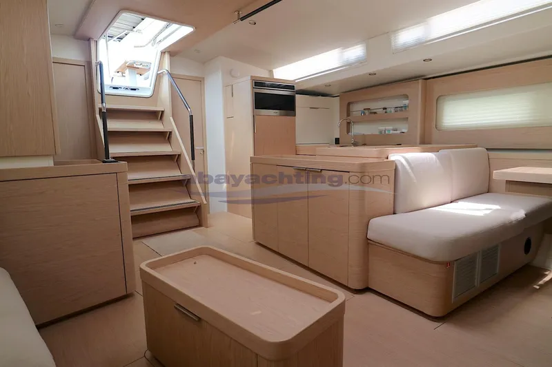  Yacht Photos Pics Modern interior of 2023 Beneteau Oceanis 54 yacht, featuring light wood finishes and spacious seating.