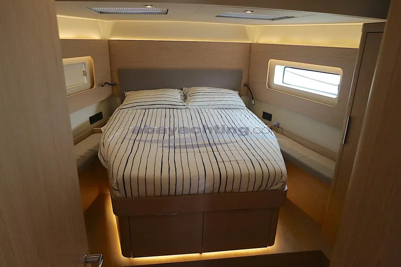  Yacht Photos Pics Luxurious cabin interior of 2023 Beneteau Oceanis 54 yacht with striped bedding.