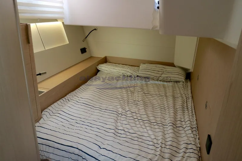  Yacht Photos Pics Interior cabin of 2023 Beneteau Oceanis 54 yacht with striped bedding.