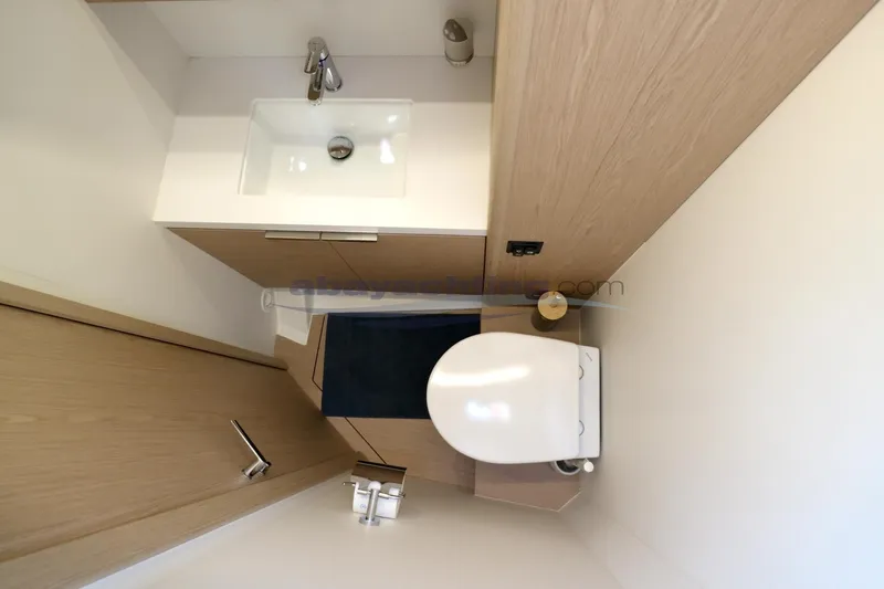  Yacht Photos Pics Modern bathroom in 2023 Beneteau Oceanis 54 yacht with sink and toilet.