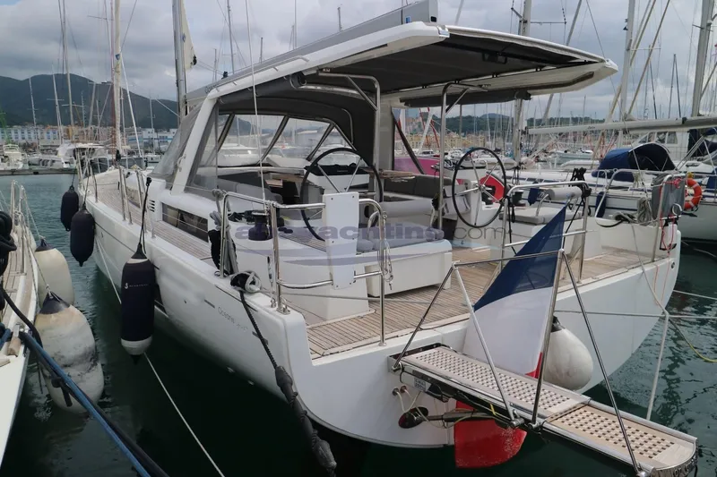  Yacht Photos Pics 2023 Beneteau Oceanis 54 yacht docked in marina, featuring sleek design and spacious deck.