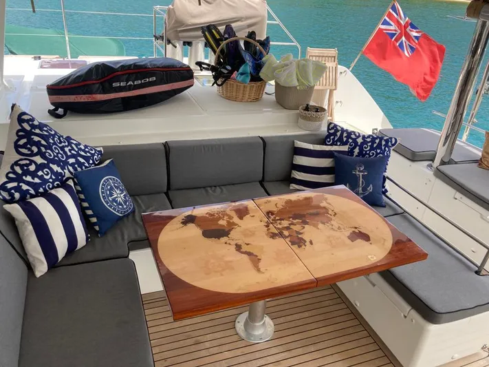 The Recipe Yacht Photos Pics Luxurious Lagoon 560 yacht deck with map table, nautical pillows, and a red flag, 2011 model.