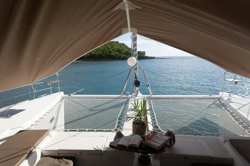 The Recipe Yacht Photos Pics Lagoon 560 catamaran deck with ocean view, featuring a cozy seating area and a potted plant.