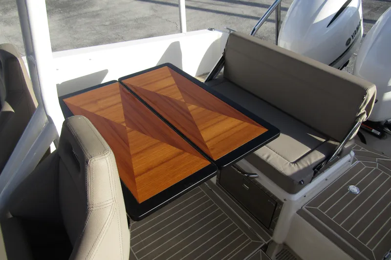  Yacht Photos Pics 2023 Windy SR28 CC boat interior with wooden table and cushioned seating.