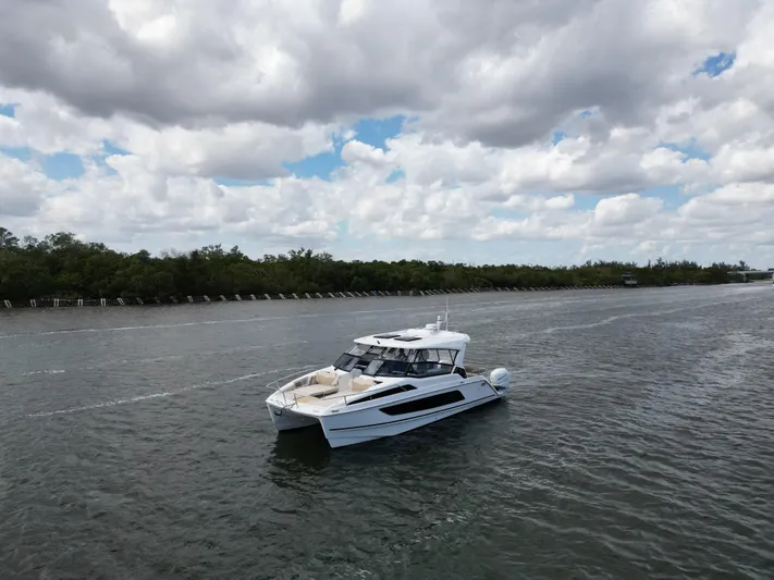 Yaffa Yacht Photos Pics Aquila 36 yacht cruising on a calm river under a cloudy sky, 2021 model.