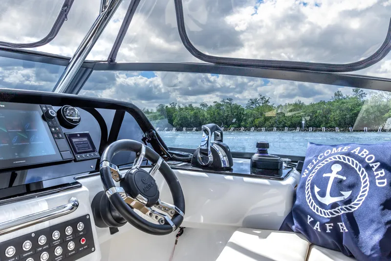 Yaffa Yacht Photos Pics Interior view of 2021 Aquila 36 boat cockpit with steering wheel and navigation system.