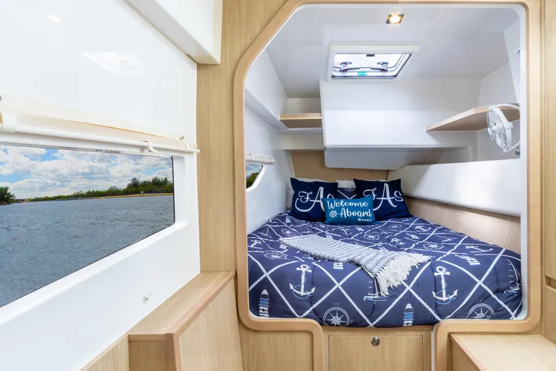 Yaffa Yacht Photos Pics Cozy cabin interior of 2021 Aquila 36 boat with nautical-themed bedding.