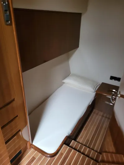 No Name Yacht Photos Pics Cozy cabin interior of 2008 Viking Convertible 60 yacht with single bed and wooden accents.