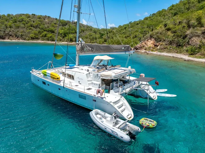 Azuria Yacht Photos Pics Lagoon 500 catamaran anchored in clear blue water, surrounded by lush green hills.