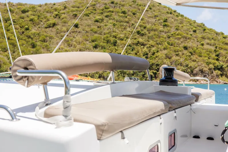 Azuria Yacht Photos Pics Luxurious Lagoon 500 catamaran deck with cushioned seating, 2011 model, scenic coastal backdrop.