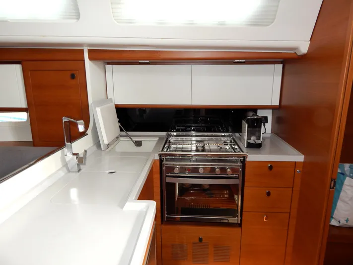  Yacht Photos Pics Italia Yachts 13.98 (2021) galley with modern appliances and sleek wooden cabinetry.