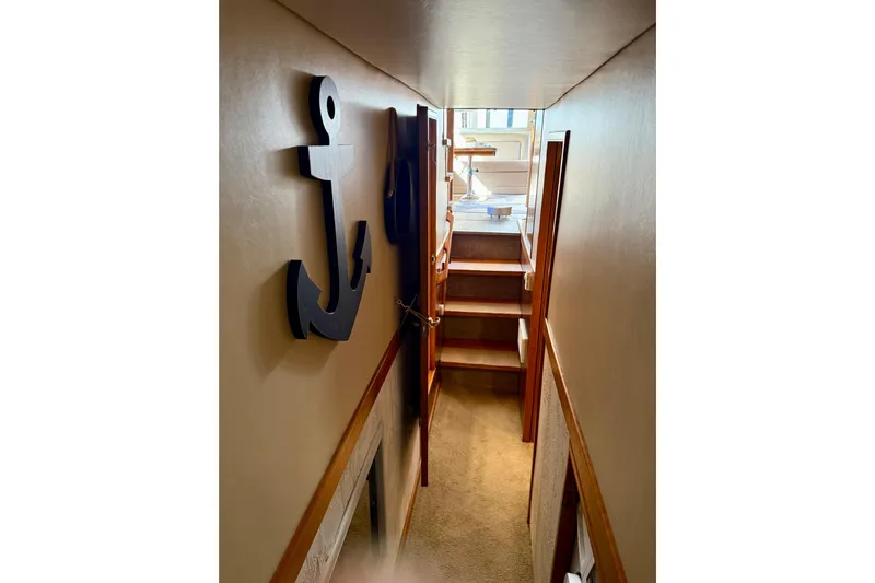 Trademarc Yacht Photos Pics Narrow hallway in 2004 Meridian 490 Pilothouse with anchor wall decor and stairs.