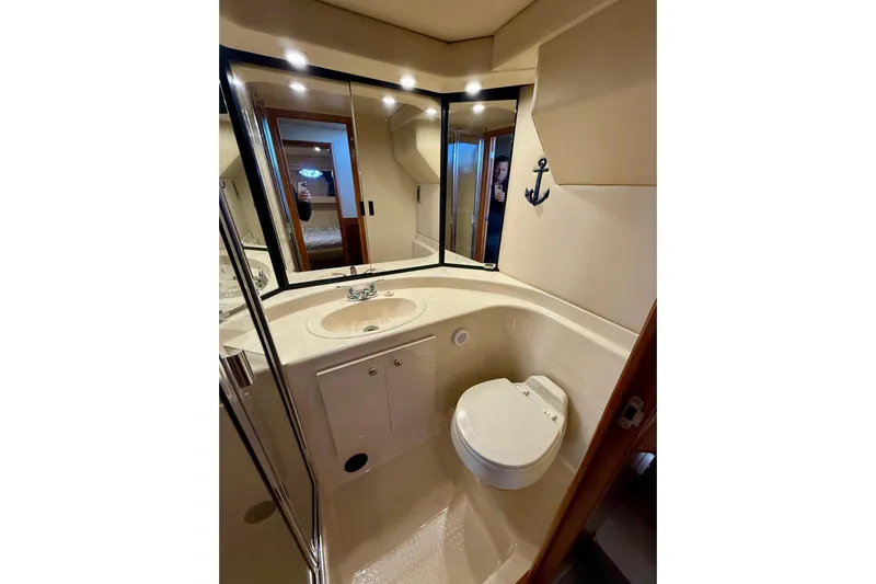 Trademarc Yacht Photos Pics 2004 Meridian 490 Pilothouse bathroom with sink, toilet, and mirrored cabinet.