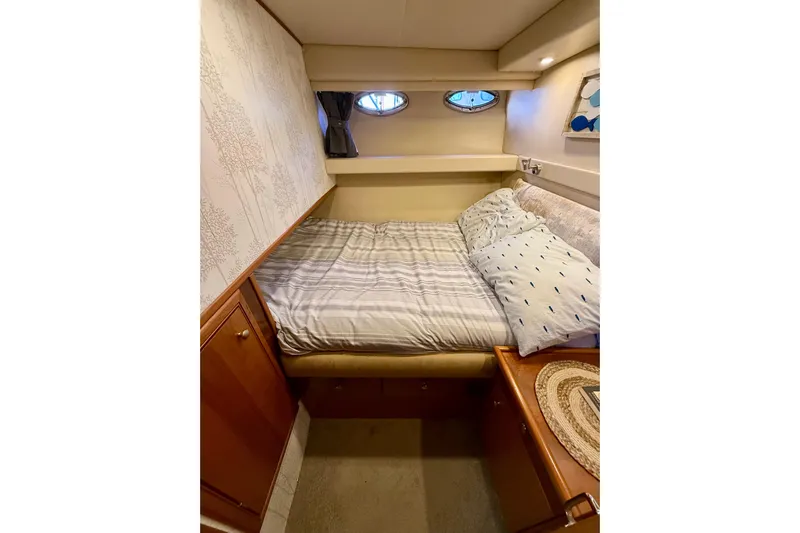 Trademarc Yacht Photos Pics Cozy bedroom in 2004 Meridian 490 Pilothouse yacht with striped bedding and wooden cabinetry.