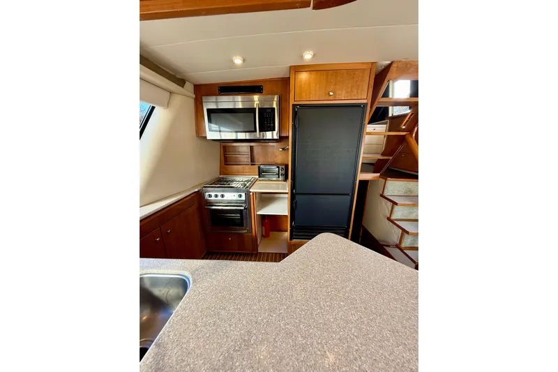 Trademarc Yacht Photos Pics 2004 Meridian 490 Pilothouse kitchen with modern appliances and wooden cabinetry.