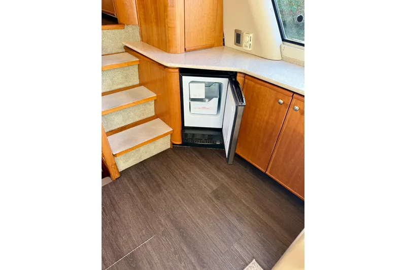 Trademarc Yacht Photos Pics Interior of 2004 Meridian 490 Pilothouse with open mini fridge and wooden cabinetry.