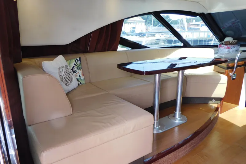 Yacht Photos Pics Luxurious interior of 2013 Sea Ray 510 Sundancer yacht with beige seating and wooden table.