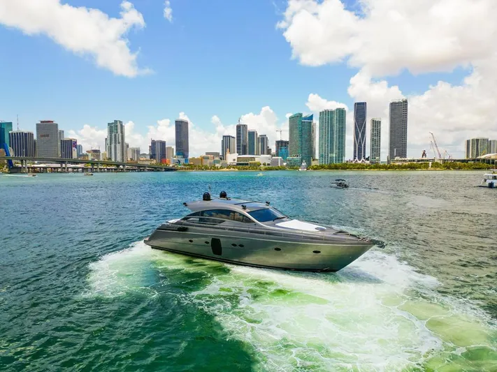 Wind Yacht Photos Pics 2009 Pershing 64 yacht cruising near a city skyline under a bright blue sky.
