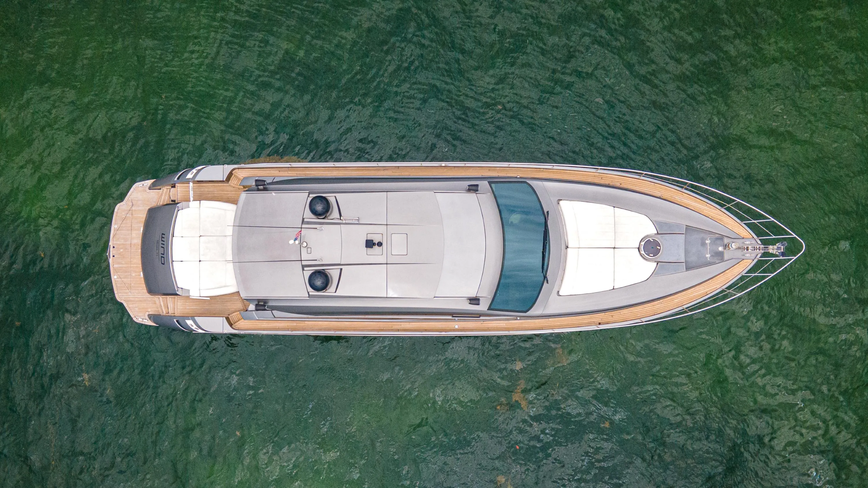 Aerial view of 2009 Pershing 64 yacht on green water.