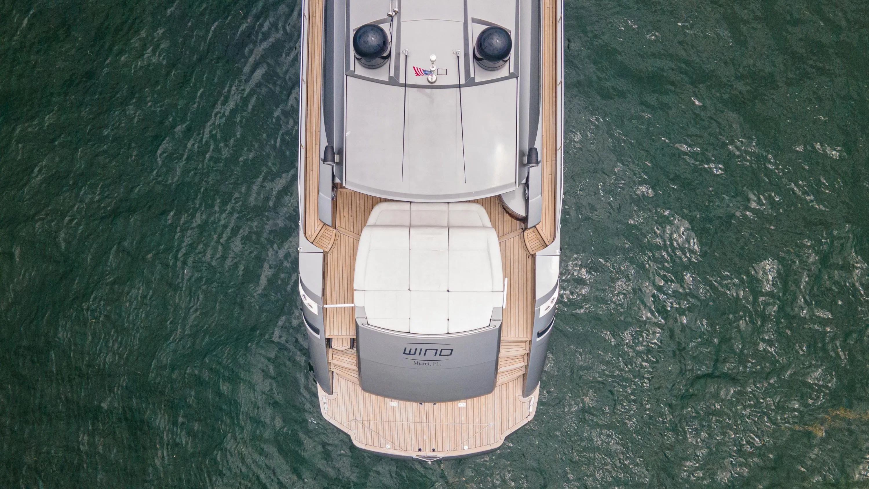 Aerial view of 2009 Pershing 64 yacht on water, showcasing sleek design and deck layout.
