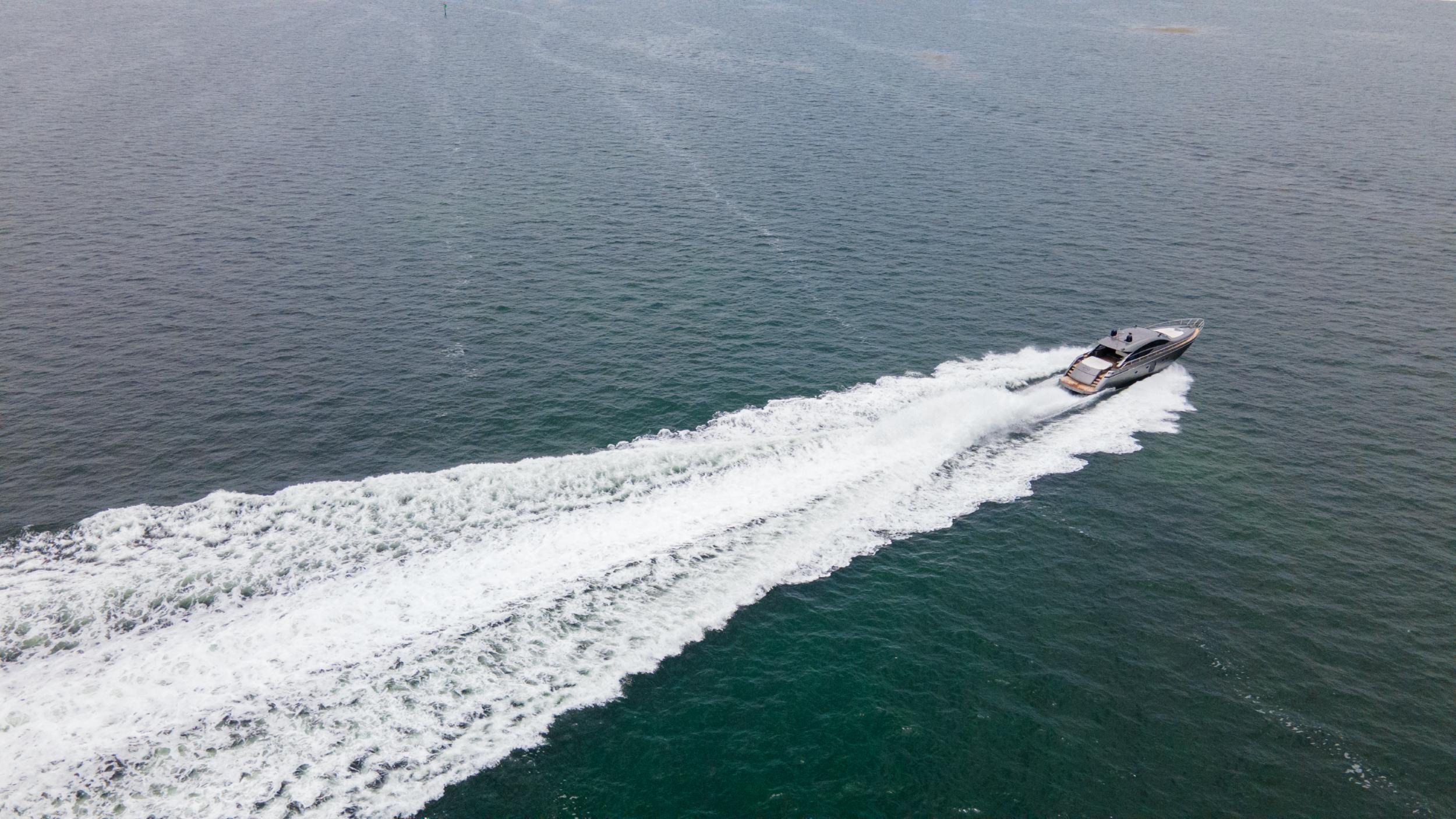 Aerial view of 2009 Pershing 64 yacht speeding on open water.