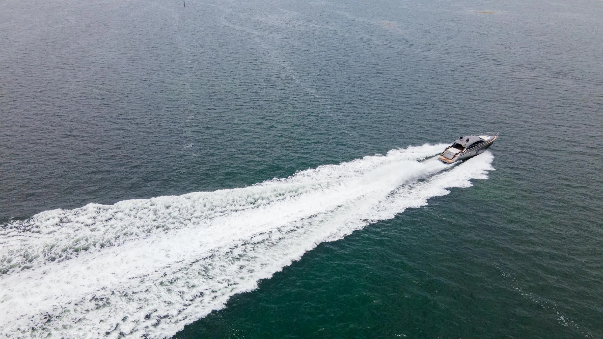 Aerial view of 2009 Pershing 64 yacht speeding on open water.
