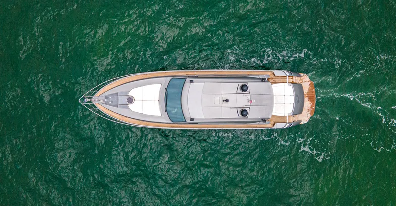 Wind Yacht Photos Pics Aerial view of 2009 Pershing 64 yacht cruising on green ocean waters.