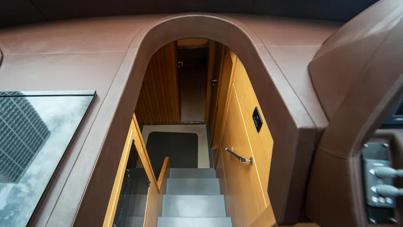 Wind Yacht Photos Pics Interior view of 2009 Pershing 64 yacht, featuring a staircase and wooden paneling.