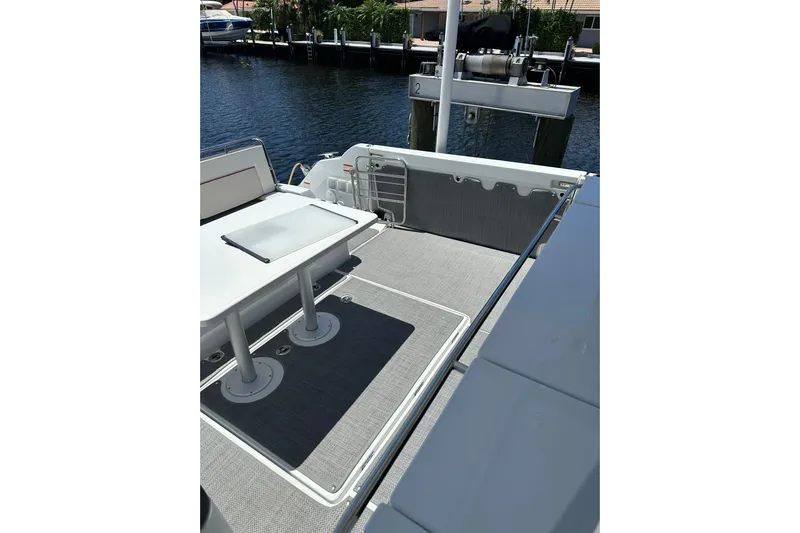  Yacht Photos Pics 2022 Jeanneau Leader 12.5 WA boat deck with table, docked by the water.