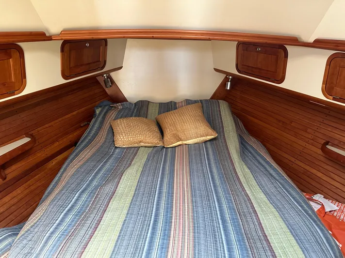 Blue Sora Yacht Photos Pics Cozy cabin interior of 2005 Legacy 42 boat with striped bedding and wooden accents.