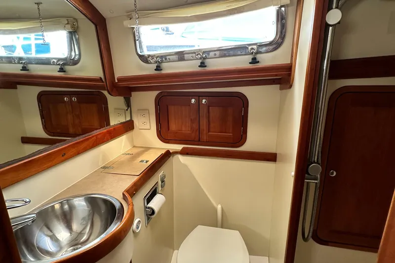 Blue Sora Yacht Photos Pics Luxurious 2005 Legacy 42 yacht bathroom with wood accents and stainless steel sink.